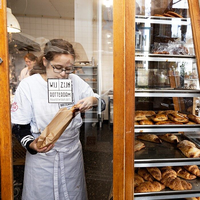 Werknemer in de winkel Bakkerswerkplaats gefotografeerd door het raam